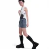 Full-body shot of a female model in urban streetwear featuring a white tank top and boots, showcasing the black SYMA Imperial modular everyday carry wallet worn as a hanging neck pouch