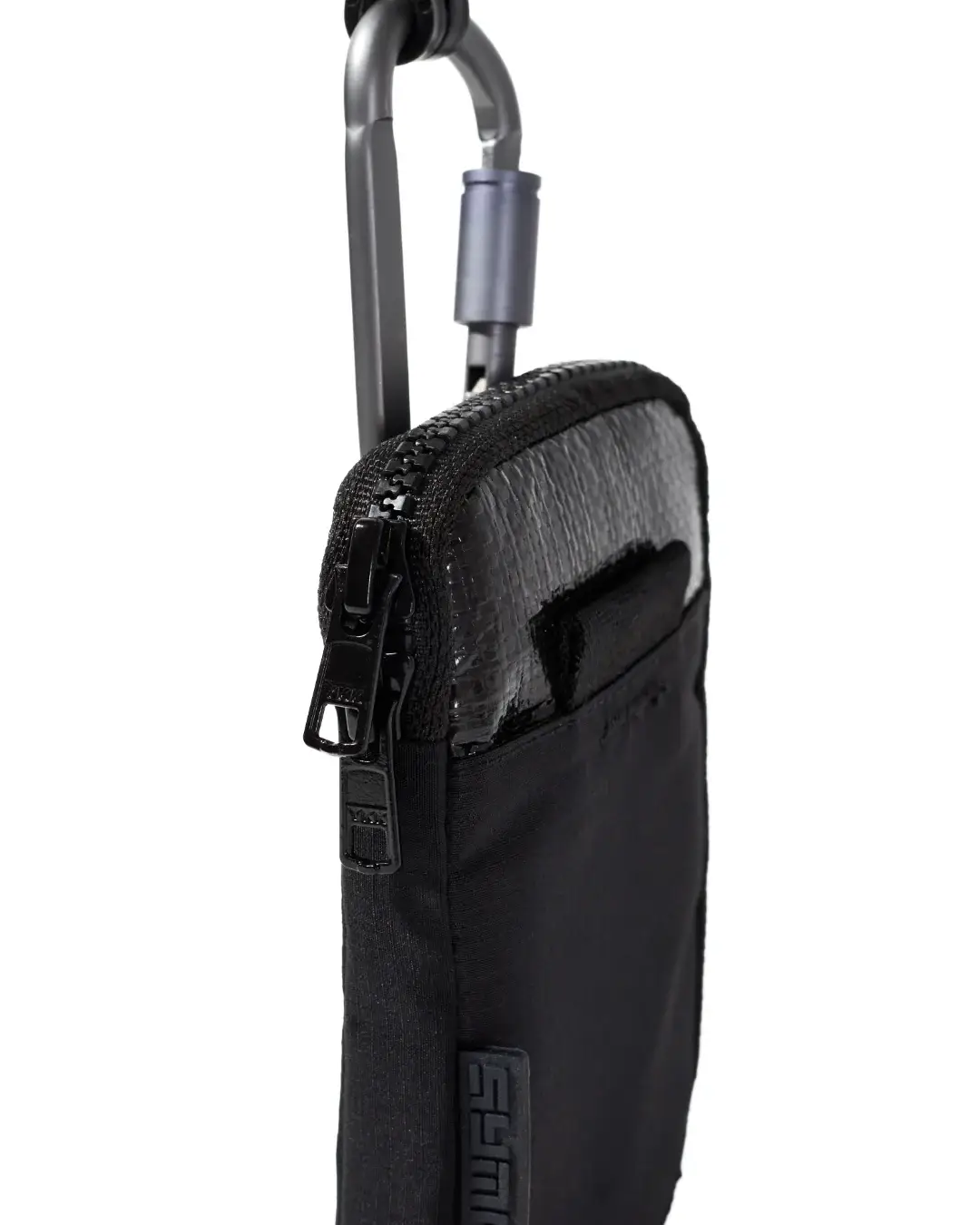 Extreme close-up detail of the black SYMA Imperial everyday carry wallet, highlighting the heavy-duty YKK Vislon zipper, top metal carabiner attachment, and contrasting tarpaulin and ripstop exterior materials