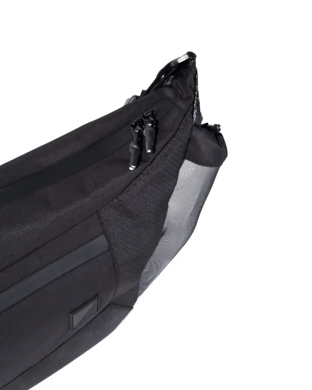 Close-up angled view of the black SYMA Drone highlighting its textured ripstop fabric, double paracord zipper pulls, and side mesh pocket. Urban sling bag.