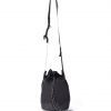 Straight suspended view of the black SYMA Sense Sling Bag hanging by its adjustable strap featuring a quick-release buckle and speckled paracord. Minimalist drawstring sling bag.