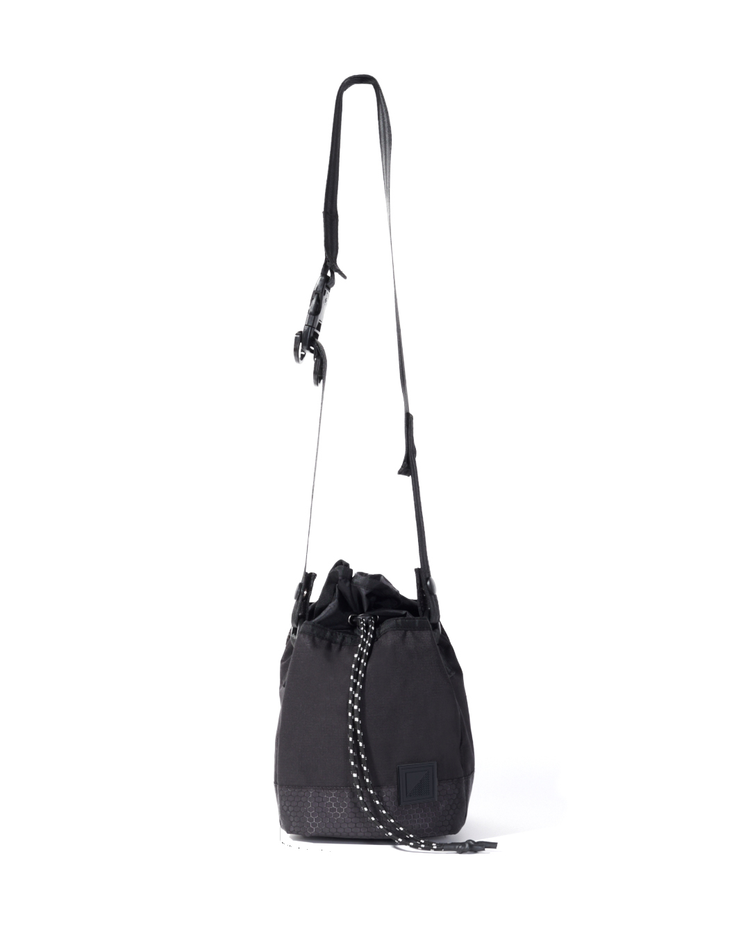 Straight suspended view of the black SYMA Sense Sling Bag hanging by its adjustable strap featuring a quick-release buckle and speckled paracord. Minimalist drawstring sling bag.