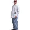 Full-body view of a male model in urban streetwear wearing the black SYMA Zipp around his neck, demonstrating its scale and card accessibility. Minimalist lanyard wallet.