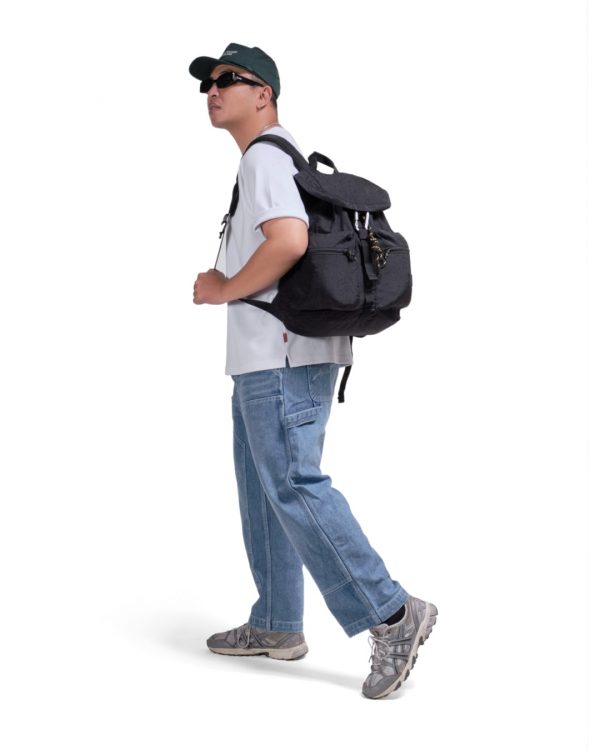 Man in casual streetwear walking with black SYMA Hover Backpack on his back. 20L versatile daily backpack