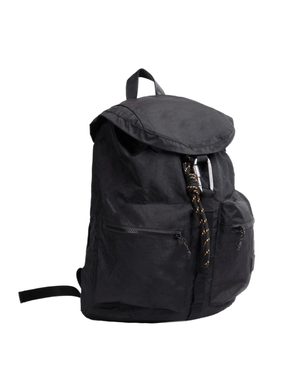 Angled view of black SYMA Hover Backpack highlighting classic flap closure, tactical carabiner, and dual front pockets. Versatile daily backpack