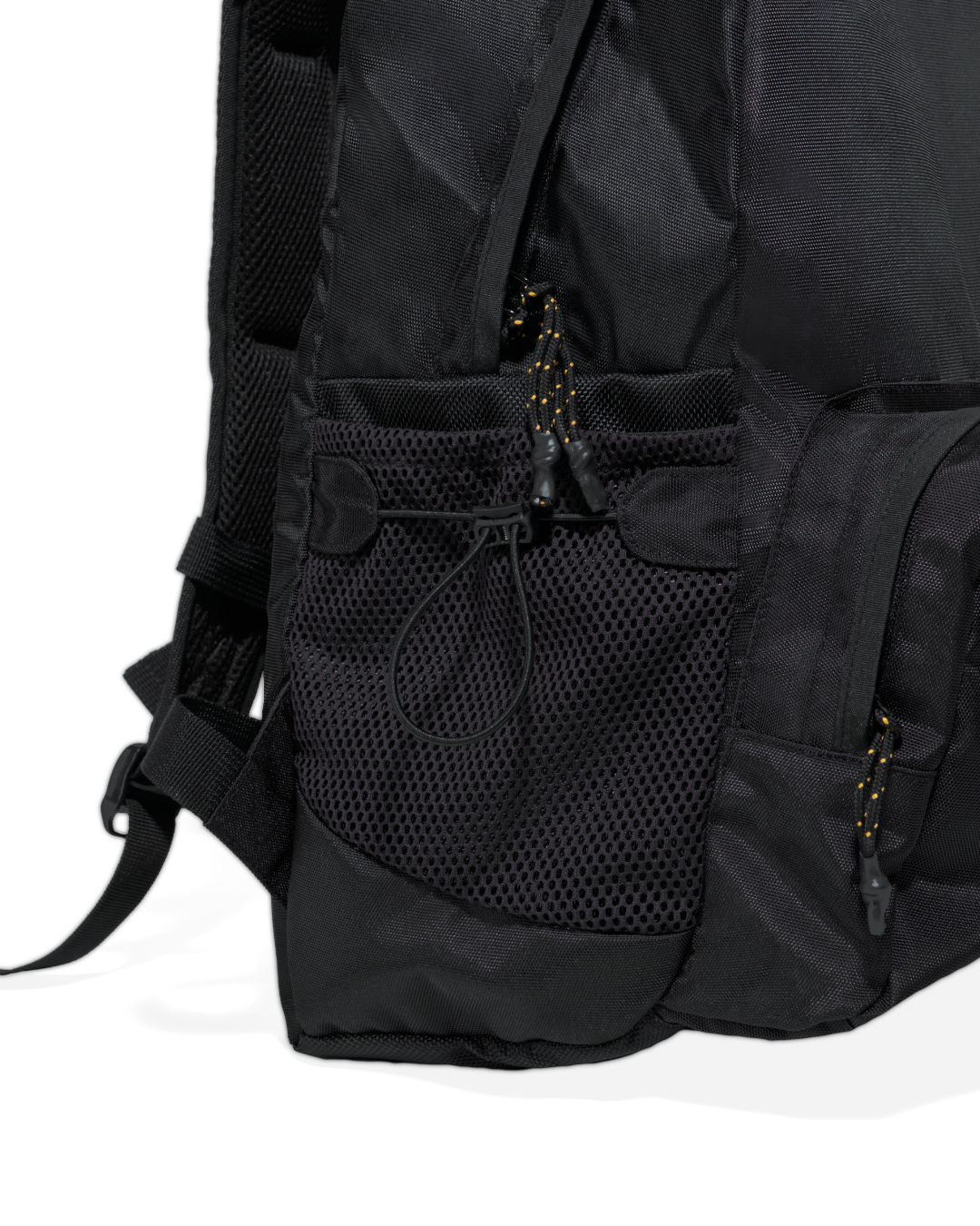 Close-up side view of the black SYMA Foyer highlighting its expandable side mesh pocket with drawstring and reinforced shoulder strap stitching. 16 inch commuter backpack.