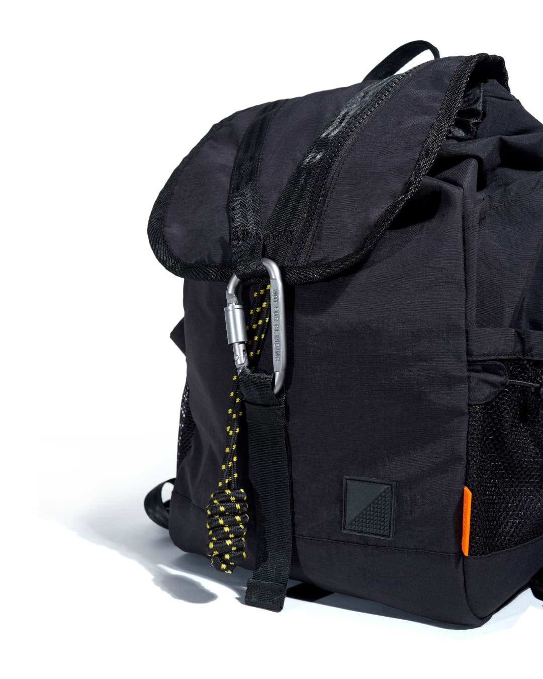 Close-up angled view of black SYMA Adore Backpack highlighting tactical carabiner and paracord details. Compact everyday backpack