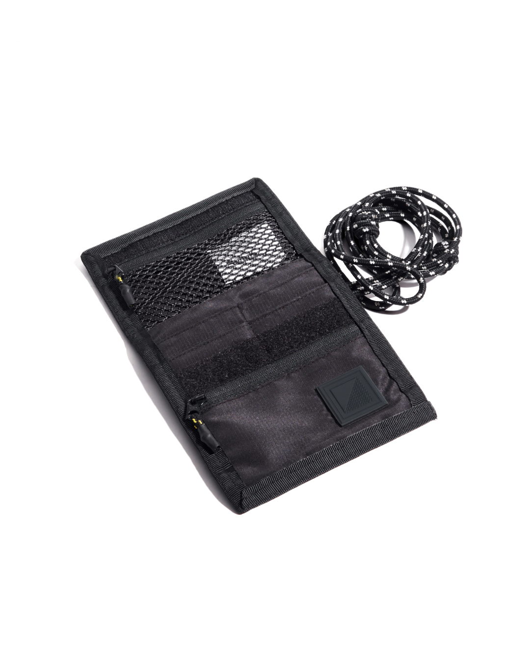 Top-down view of the empty open black SYMA Arrival compact travel wallet, detailing the internal mesh pocket, card slots, velcro closure, and custom paracord strap