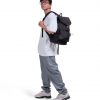 Man in casual streetwear wearing black SYMA Outrun Backpack. 21L versatile everyday backpack