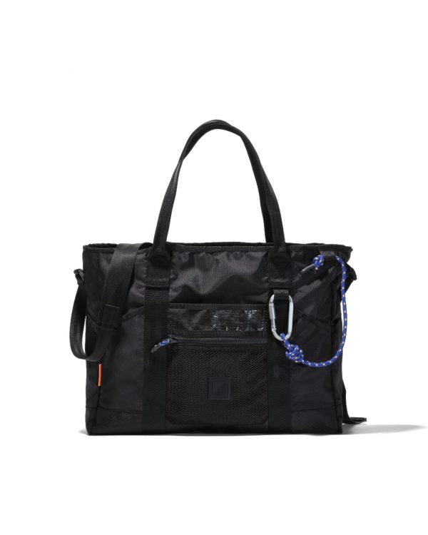 Front view of black SYMA Miles Tote Bag highlighting front mesh pocket and tactical carabiner with blue paracord. Versatile work tote bag
