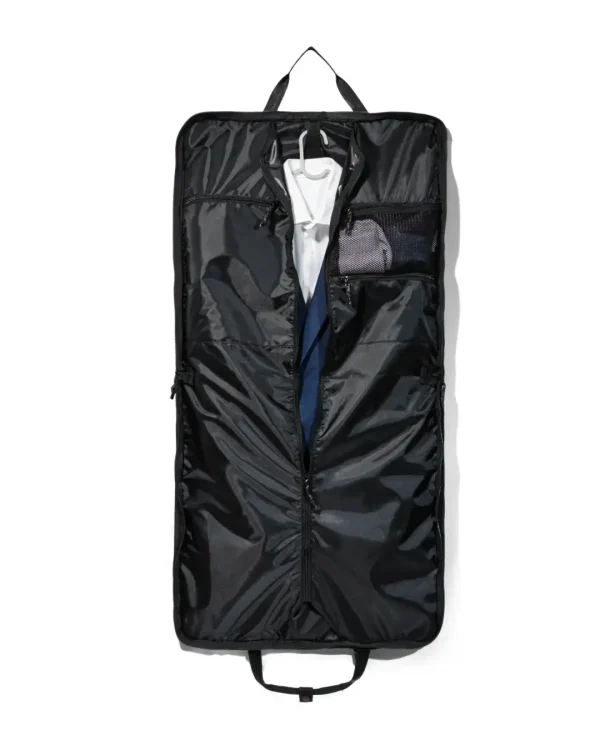 Straight interior view of the fully unzipped black SYMA Motion revealing a white shirt and navy suit jacket on a hanger, alongside an internal mesh pocket. Travel garment bag.