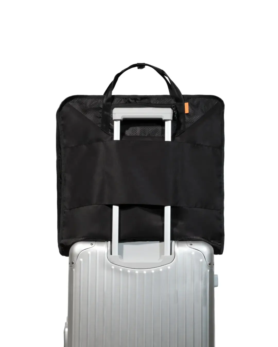 Straight rear view of the folded black SYMA Motion secured to a silver rolling suitcase handle via its luggage slip-through sleeve. Travel garment bag.