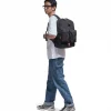 Man in casual urban attire walking with black SYMA Ascend Backpack on his back. 20L structured everyday backpack