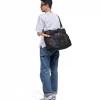 SYMA. Miles Racket-Tote Black worn by man carrying racket. Premium urban utility padel & tennis bag