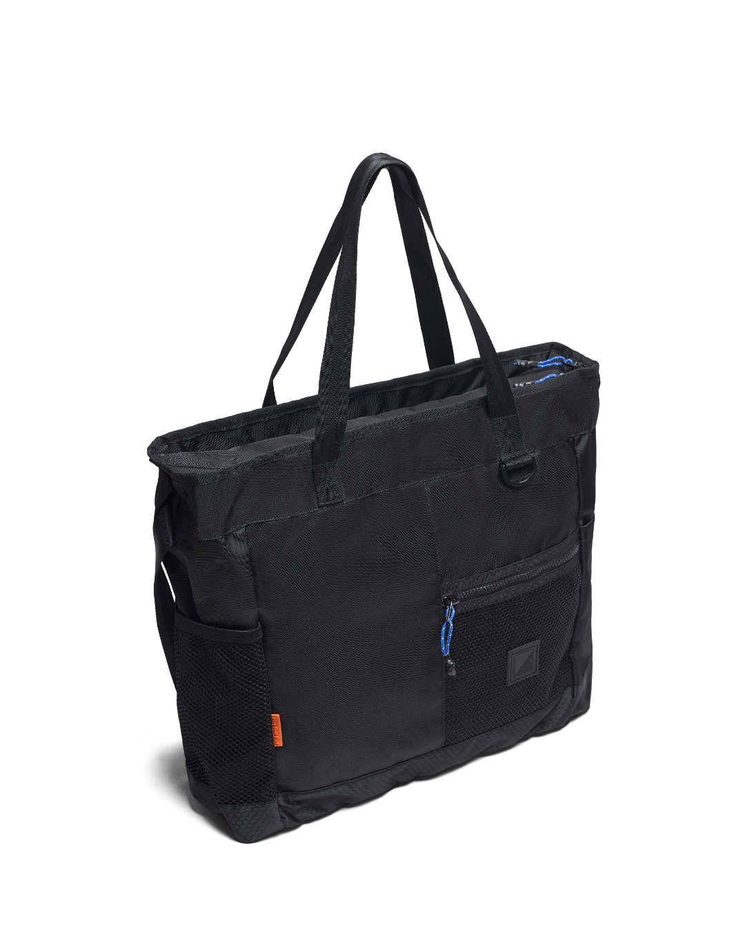 Three-quarter angled view of the black SYMA Bridge Tote Bag, a premium urban utility tote highlighting its side mesh water bottle pocket with an orange tag, spacious structured capacity, and front zippered mesh pocket with a blue paracord puller